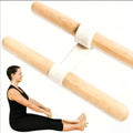 Two wooden yoga wheel bars connected by a white fabric strap, shown with a woman in a seated position demonstrating use on a white background.